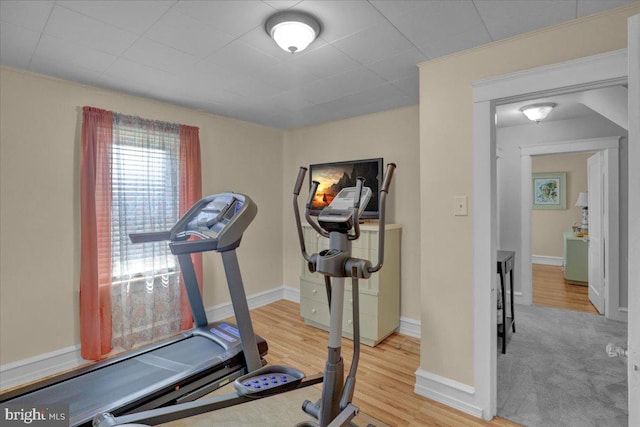 exercise room with baseboards and wood finished floors