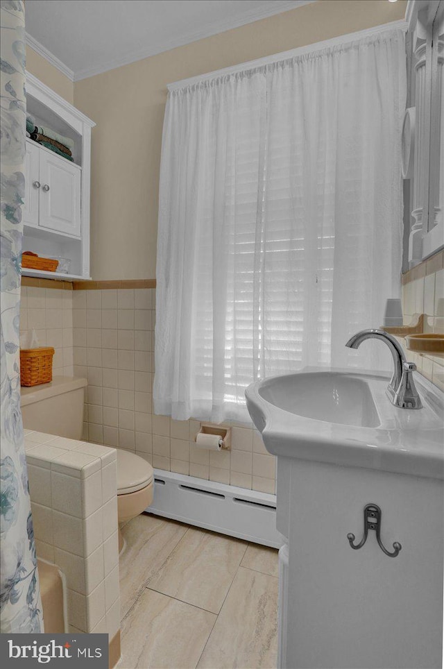 full bathroom featuring baseboard heating, vanity, toilet, tile walls, and ornamental molding
