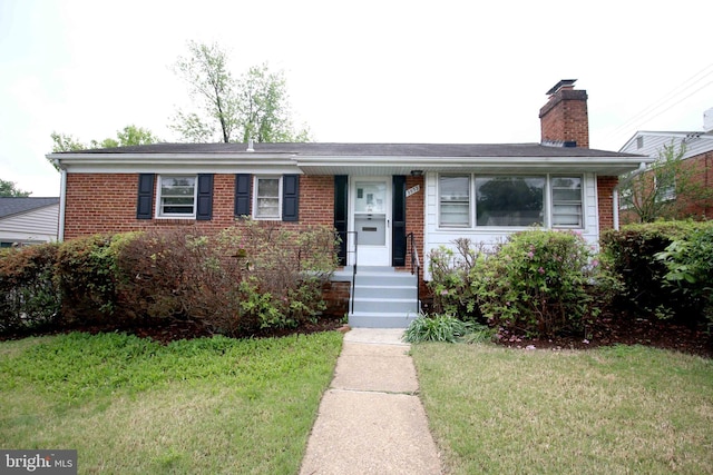 ranch-style house featuring brick siding, a front yard, and a chimney