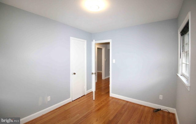 empty room with baseboards and light wood-style floors