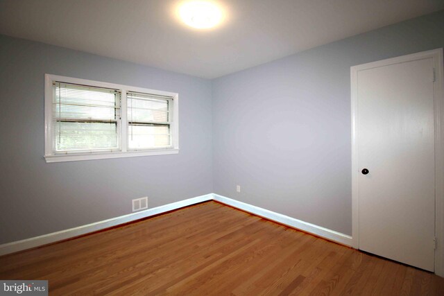 unfurnished room featuring wood finished floors and baseboards