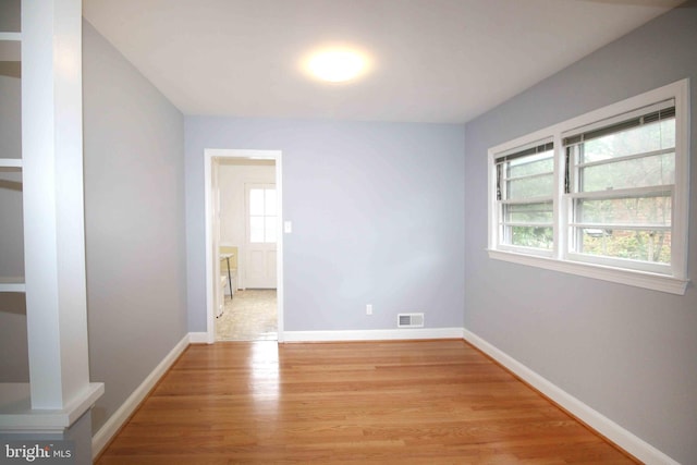 spare room with light wood-type flooring and baseboards