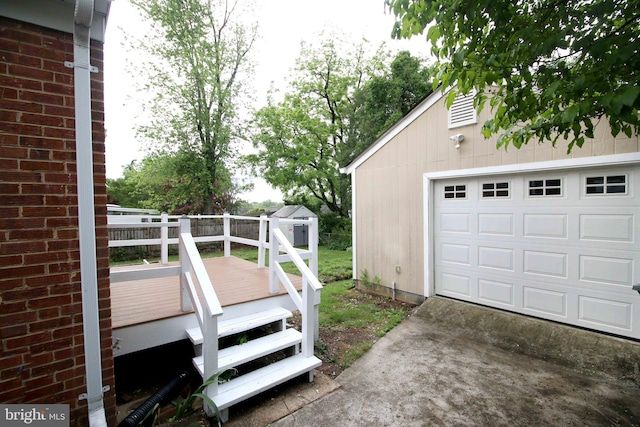view of home's exterior featuring a deck, an outdoor structure, and driveway