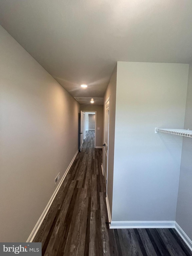 hall featuring baseboards, visible vents, recessed lighting, and dark wood-style flooring