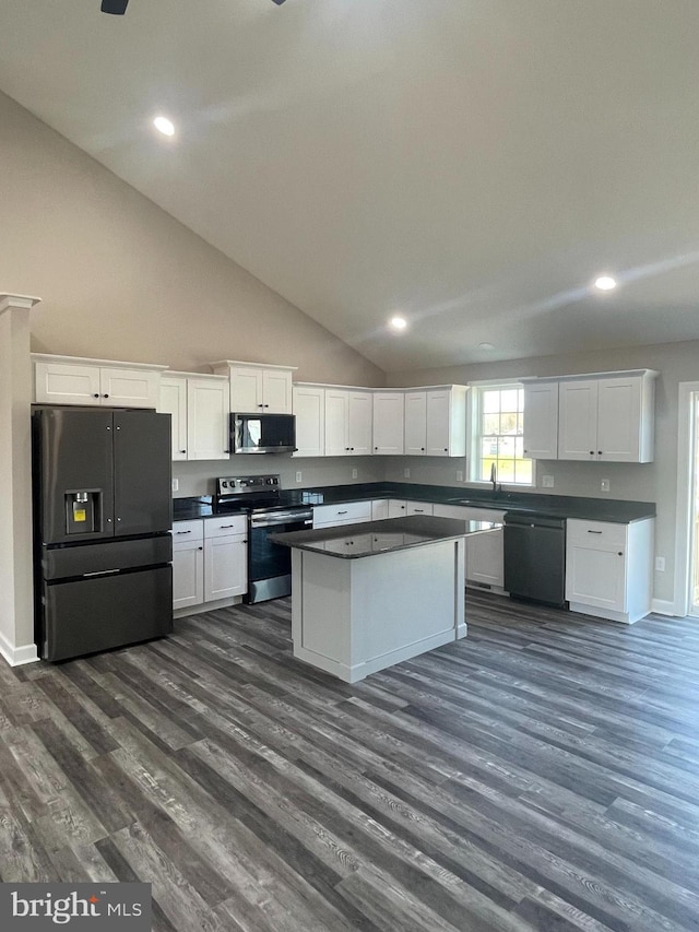 kitchen featuring dark wood-type flooring, dark countertops, white cabinets, and black appliances