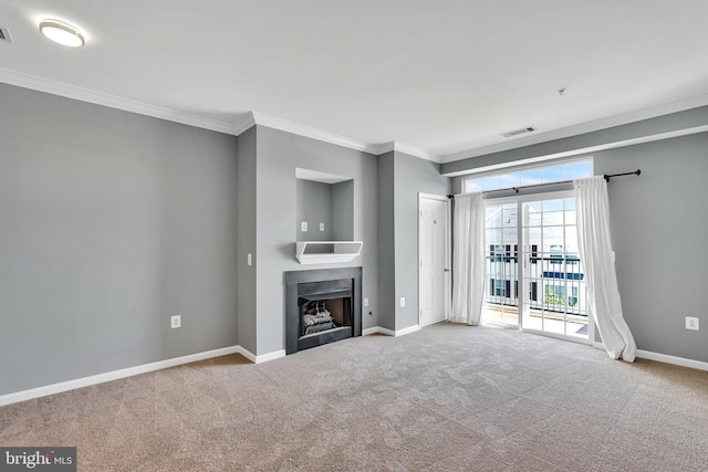 unfurnished living room featuring visible vents, ornamental molding, carpet floors, baseboards, and a fireplace