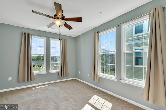 unfurnished room featuring carpet floors, a healthy amount of sunlight, and visible vents