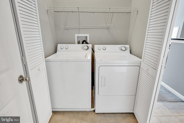 washroom featuring washer and clothes dryer, laundry area, and light tile patterned floors