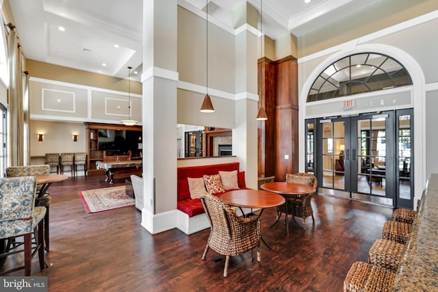 dining area with plenty of natural light, wood finished floors, and a high ceiling