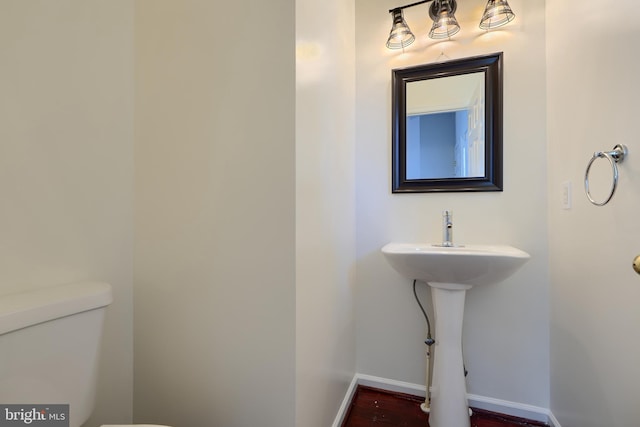 724 Tinker Rd, Middle River, MD 21220 - bathroom featuring toilet, baseboards, and wood finished floors