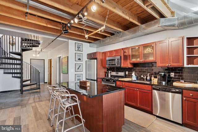 810 N Hancock St Unit 5, Philadelphia, PA 19123 - kitchen with a kitchen island, dark countertops, a breakfast bar, a sink, and appliances with stainless steel finishes
