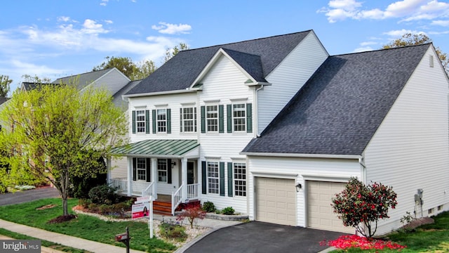 view of front of house featuring a garage, a shingled roof, covered porch, and aphalt driveway