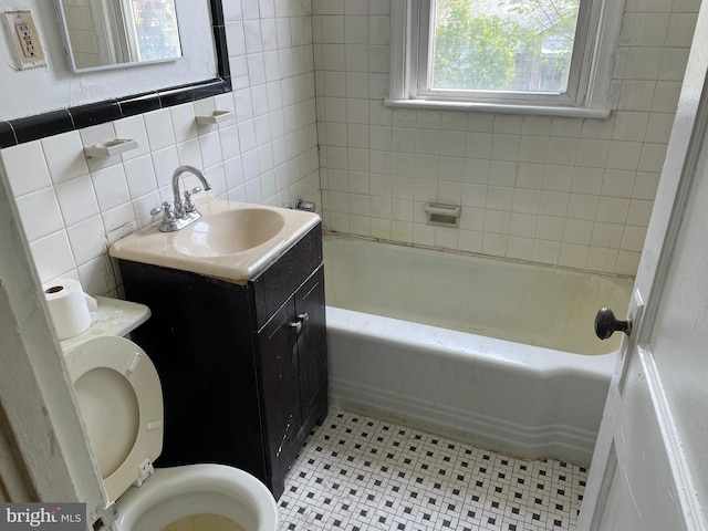 full bath with tile patterned flooring, toilet, vanity, tile walls, and a bathing tub