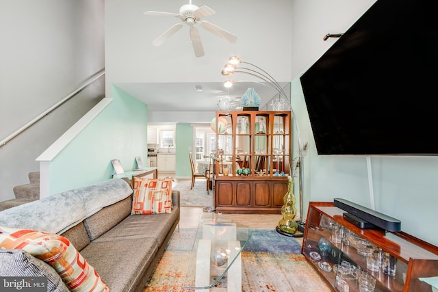 living area featuring stairway, a high ceiling, and ceiling fan