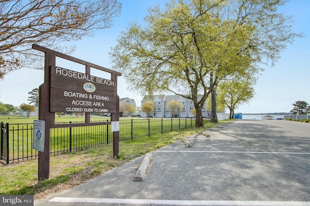 exterior space with a lawn, uncovered parking, and fence