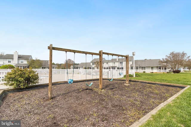 exterior space with a residential view, a lawn, fence, and playground community