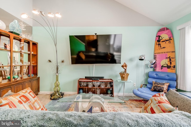 living room featuring baseboards, wood finished floors, and vaulted ceiling