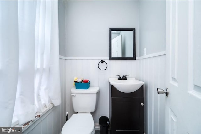 235 Maple St, Reading, PA 19602 - bathroom with vanity, toilet, and a wainscoted wall