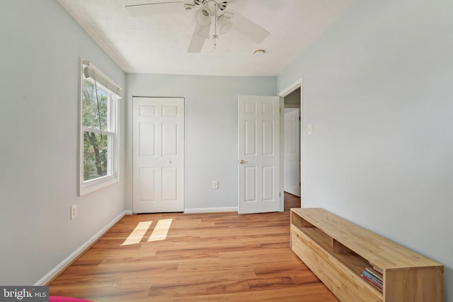 unfurnished bedroom with light wood-type flooring, baseboards, ceiling fan, and a closet