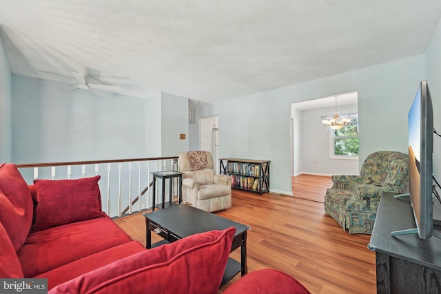 living room featuring a chandelier, wood finished floors, and ceiling fan