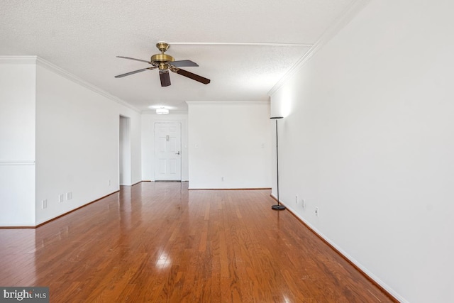 unfurnished room with ceiling fan, baseboards, ornamental molding, and wood finished floors