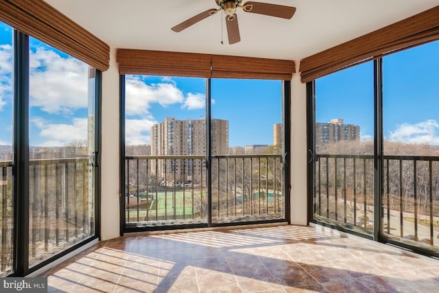 unfurnished sunroom featuring plenty of natural light, tile patterned floors, and a view of city