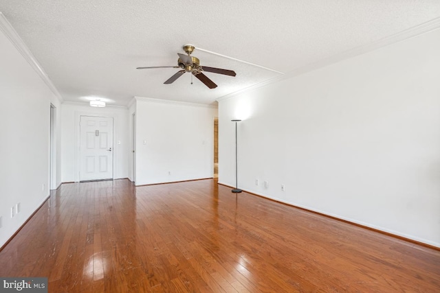 spare room with a textured ceiling, baseboards, ceiling fan, hardwood / wood-style flooring, and ornamental molding