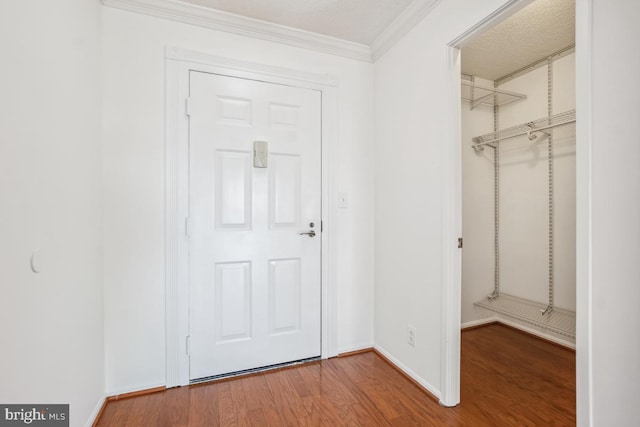 interior space featuring baseboards, wood finished floors, and crown molding