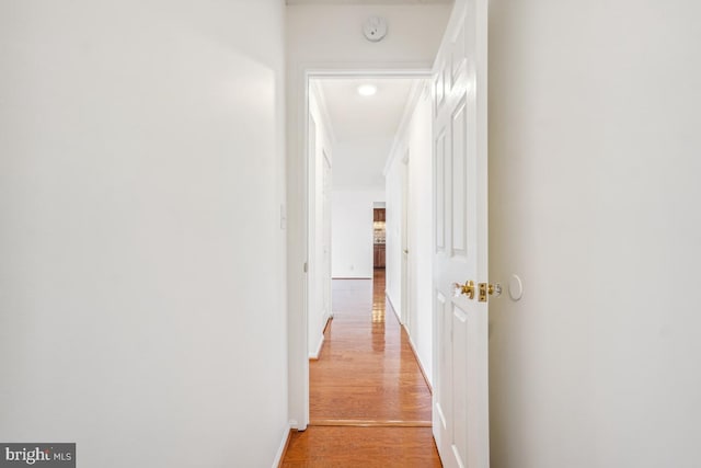 corridor with light wood finished floors and baseboards
