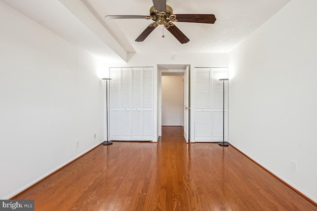 unfurnished bedroom with baseboards, a ceiling fan, and wood finished floors