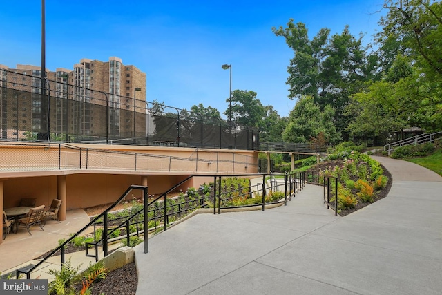 surrounding community with fence and a tennis court