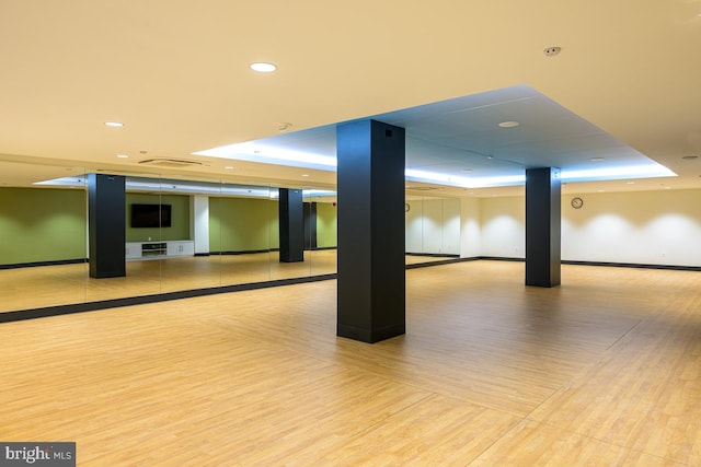 basement featuring baseboards, wood finished floors, and recessed lighting