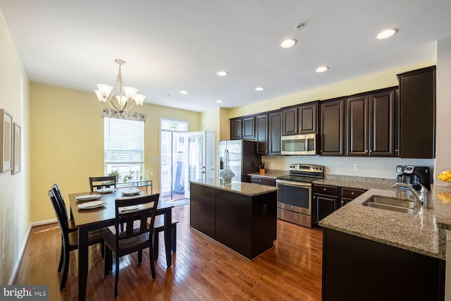 748 S Macon St, Baltimore, MD 21224 - kitchen with appliances with stainless steel finishes, a sink, a center island, a chandelier, and light stone countertops