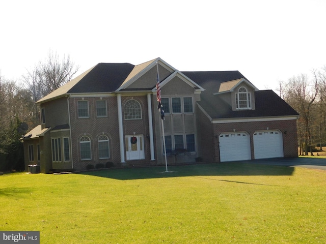 view of front of home featuring a front lawn, brick siding, driveway, and an attached garage