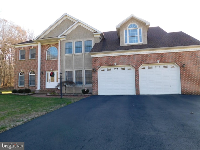 view of front of home with an attached garage, a front lawn, driveway, and brick siding