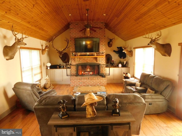 living room with a fireplace, vaulted ceiling, wood-type flooring, and a ceiling fan