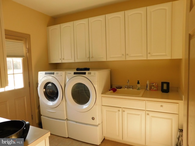 washroom featuring washing machine and dryer, a sink, and cabinet space