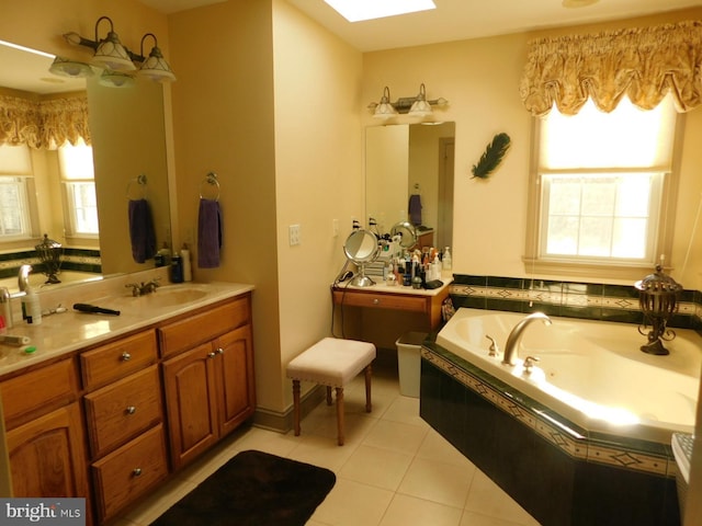 full bathroom with a whirlpool tub, vanity, tile patterned flooring, and a skylight