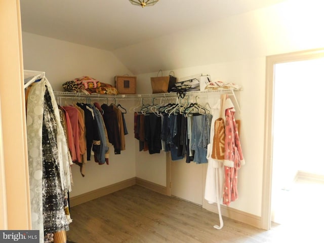 walk in closet featuring light wood-style floors and lofted ceiling