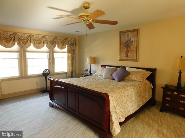 bedroom with ceiling fan, baseboards, and light carpet
