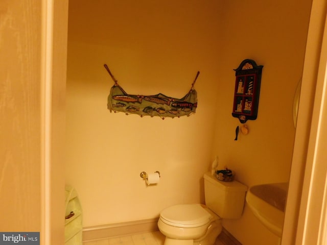 half bath with tile patterned flooring and toilet