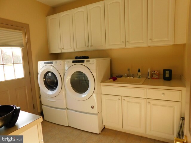 laundry area with washer and clothes dryer, cabinet space, a sink, and light tile patterned flooring