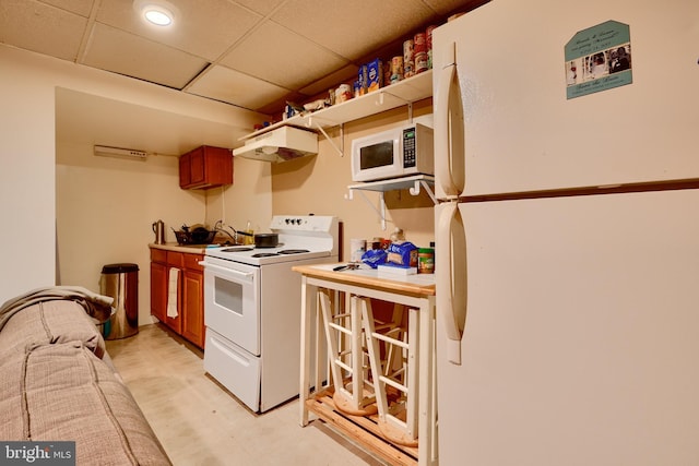4315 Washington Blvd, Halethorpe, MD 21227 - kitchen featuring white appliances, under cabinet range hood, light countertops, brown cabinetry, and a drop ceiling
