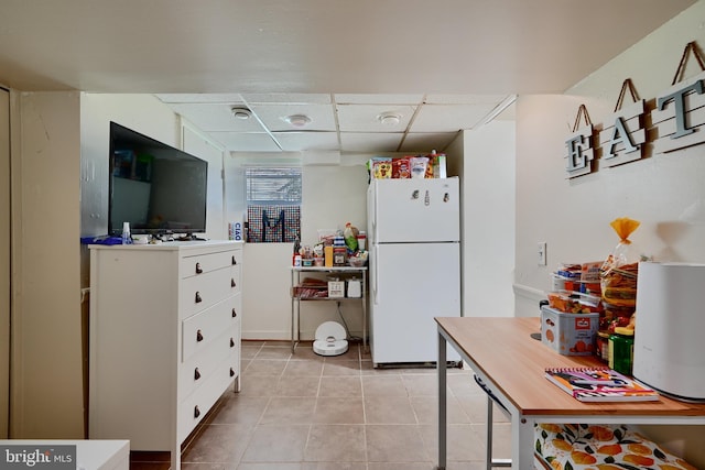 4315 Washington Blvd, Halethorpe, MD 21227 - kitchen featuring freestanding refrigerator, white cabinets, light tile patterned floors, and a paneled ceiling