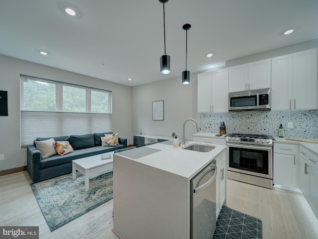 2109 M St NE Unit 5, Washington, DC 20002 - kitchen featuring appliances with stainless steel finishes, a sink, light wood-style floors, backsplash, and recessed lighting