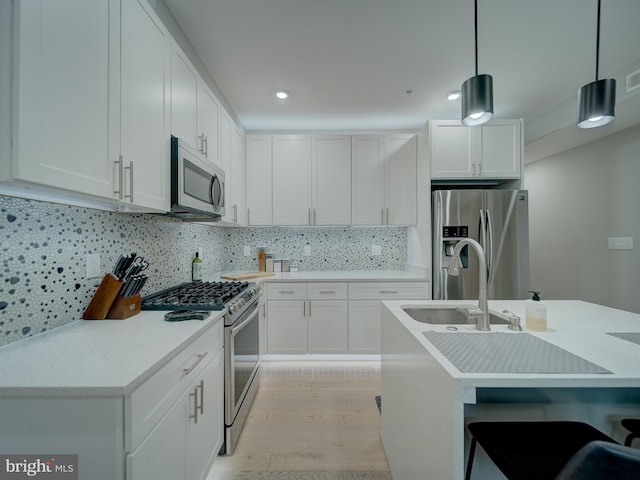 2109 M St NE Unit 5, Washington, DC 20002 - kitchen with stainless steel appliances, a sink, light wood finished floors, hanging light fixtures, and light countertops