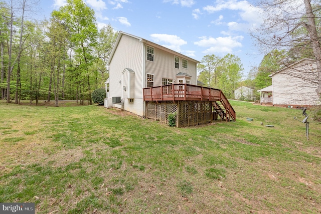 rear view of property with a yard, stairway, and a deck