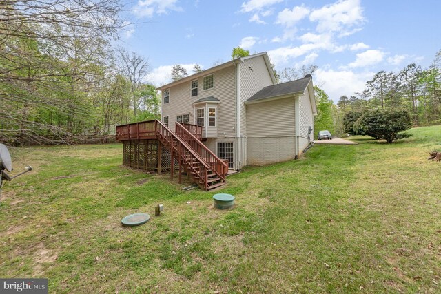 back of property featuring a lawn, a wooden deck, and stairs