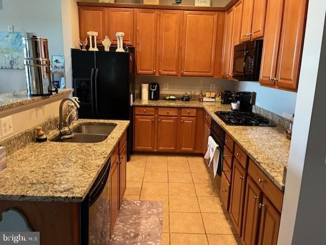 kitchen with brown cabinets, light tile patterned flooring, a sink, and black appliances
