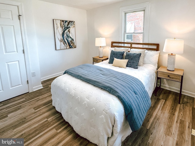 bedroom with wood finished floors and baseboards